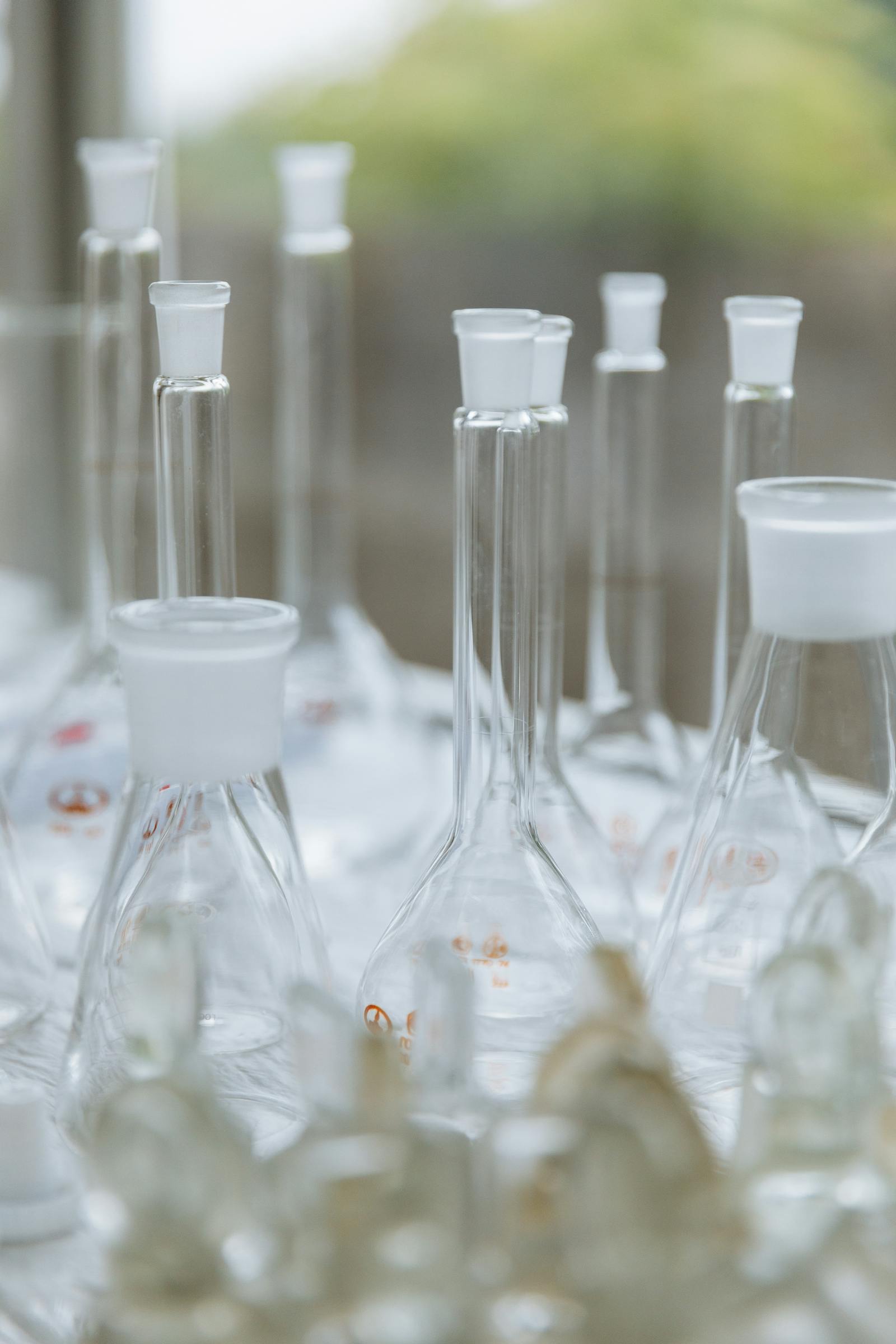 Sticlărie de laborator goală în lumină slabă, reprezentând chimia cosmetică și știința reglementară din spatele restricțiilor Methylisothiazolinone