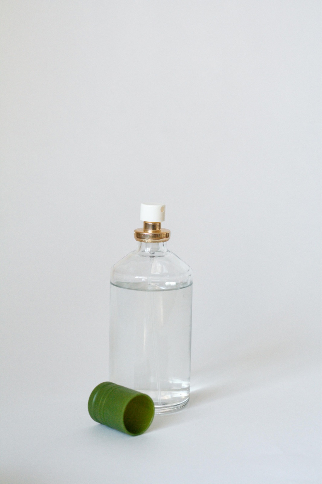 Sticluță minimală de parfum din sticlă pe o suprafață neutră reprezentând regulile UE de declarare a parfumului pentru alergenii de parfum