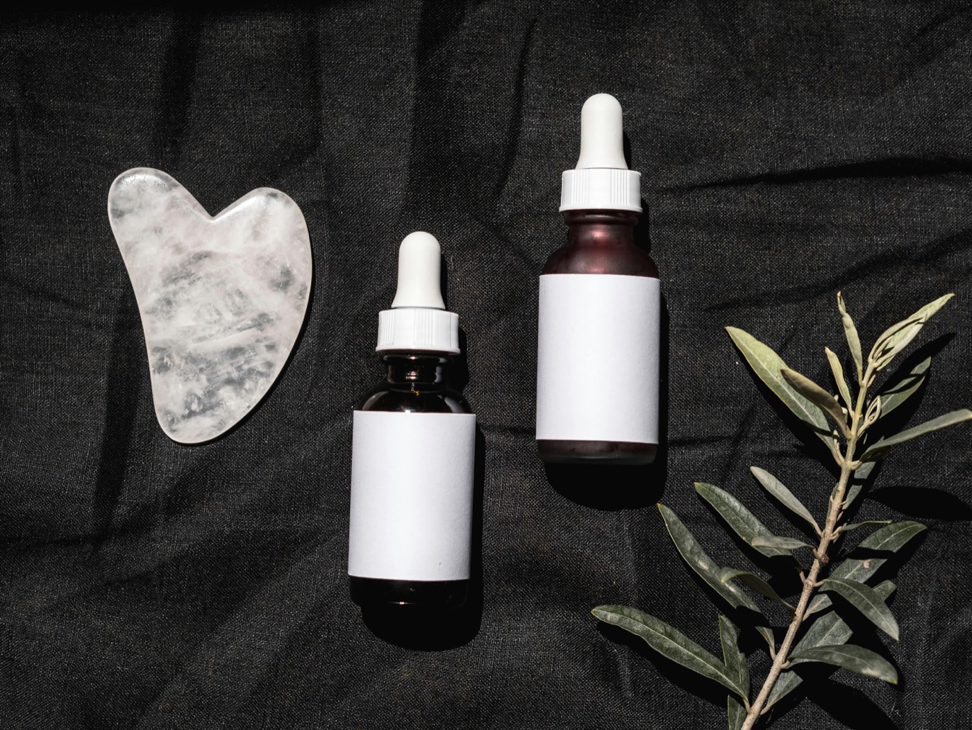 Aranjament minimalist de skincare reprezentând o rutină 2026 cu sticluțe, borcane și ingrediente active în tendințe