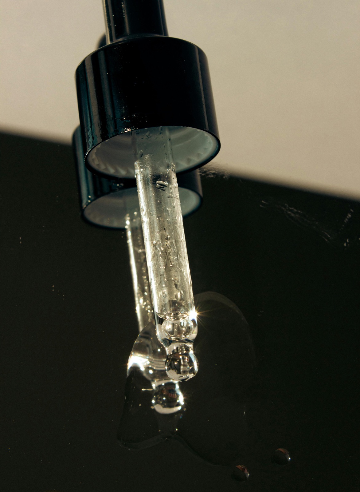 Sticluță de sticlă cu pipetă a unui ser de Tranexamic Acid pentru luminozitate pe un fundal neutru curat